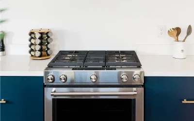 A clean white kitchen with a stove and spice rack